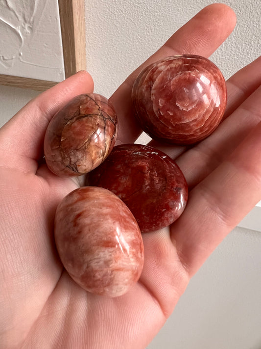 Red feldspar palm tumbles